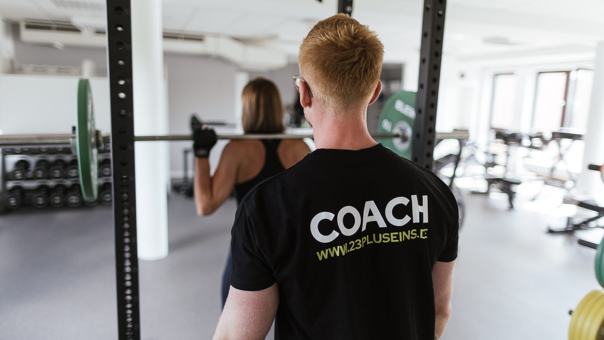 Personal Trainer erklärt Übung im Fitnessstudio